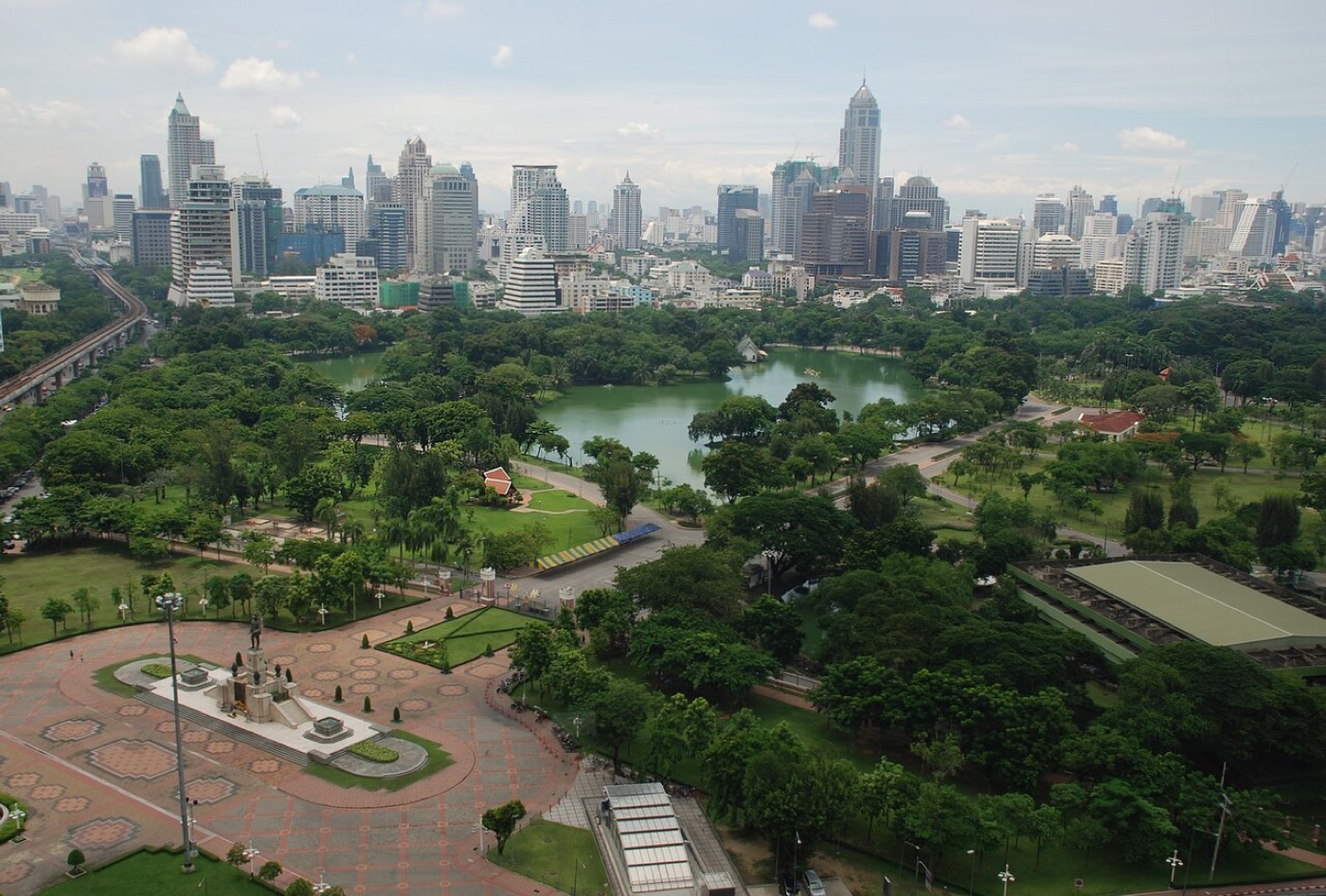 Aerial panoramic view of Lumphini Park surrounded by Bangkok skyscrapers