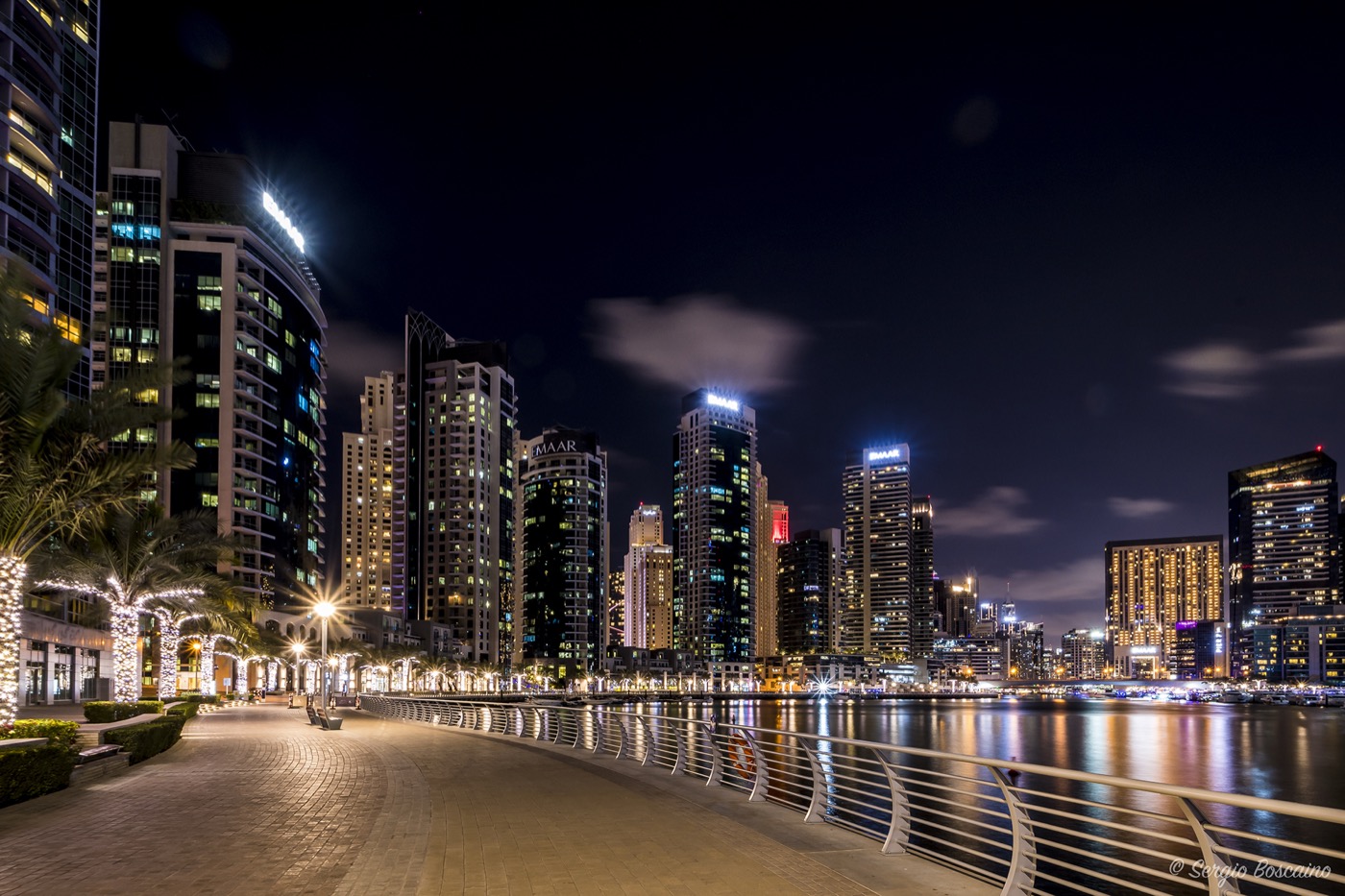 Dubai Marina waterfront promenade with yachts and luxury residential high-rises